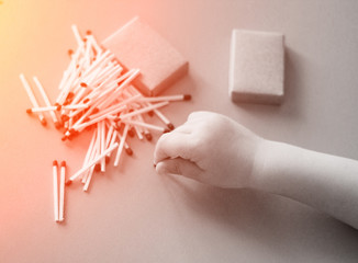 A small child plays with matches, a fire, a fire flares up, danger, child and matches, lucifer match