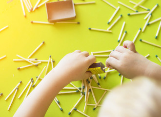 A small child plays with matches, matches matches into boxes, close-ups, fire, lucifer match, hand