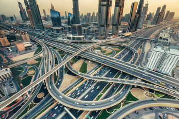 Fototapeta premium Widok z lotu ptaka na skrzyżowaniu dużych autostrad w Dubaju, ZEA, o zachodzie słońca. Koncepcja transportu i komunikacji.