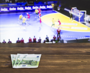 Euro money on the background of the TV on which show handball, sports betting, handball and euro