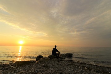 loneley man sitting worried by the sea