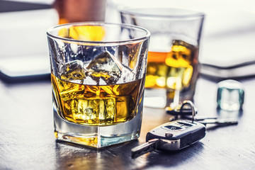 Car keys and glass of alcohol on table in pub or restaurant