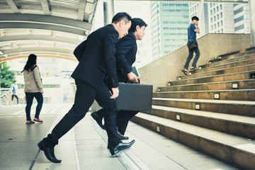 Group of business people rush hour to work with the city's background.They go to work late.