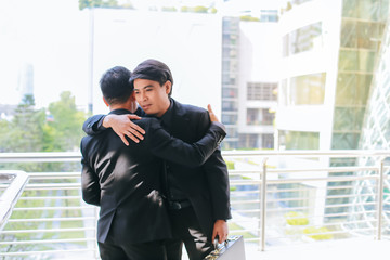 Businesspeople say goodbye to their friends and embrace each other to congratulate their newly assigned project colleagues.