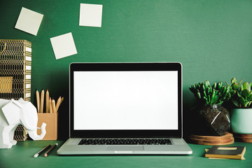 Creative desk with laptop mock up screen, books, plants, office accessories, elephant fgures and...