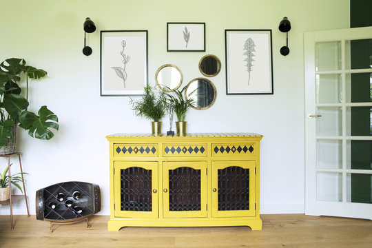 Living room with yellow cupboard, wooden floor and plants