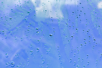 drops of water on the surface of a blue glass