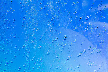 drops of water on the surface of a blue glass