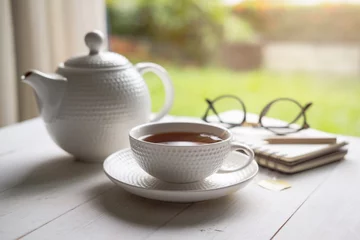 Fotobehang Thee Kopje thee op witte houten tafel met natuur achtergrond