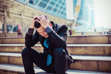Fototapeta premium Businessman were disappointed at the rejected business projects offered to customers,he sat on the steps with hands on head.