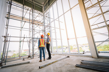 Engineers are meeting and pointed to the plan building in the office to consult a construction tools with security.