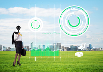Camera headed woman standing on green grass against modern cityscape