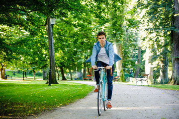 Young man biking in city park 