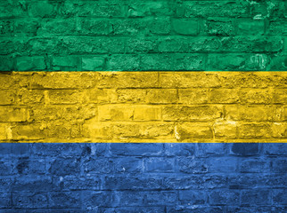 Flag of Gabon over an old brick wall background, surface