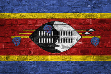 Flag of Swaziland over an old brick wall background, surface