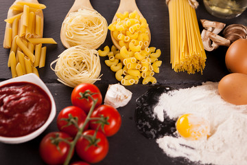 Healthy and delicious food - Four types of raw uncooked pasta next to tomatoe souce, fresh...
