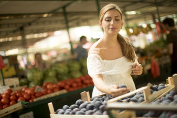 Young woman buying fruits on the market