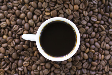 cup of coffee on coffee beans close up