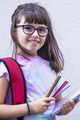 student with backpack and painting with pencils in the notebook