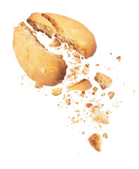 Cookies broken into two halves with falling crumbs down, isolated on white background