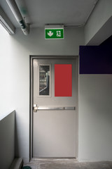 Fire exit emergency door grey color metal material and concrete floor and white wall