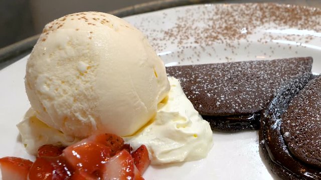 Motion video of chocolate pancakes, strawberry and vanila ice cream on dish, dessert in the restaurant