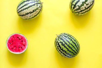 Bright summer yellow background with watermelons. Flat lay