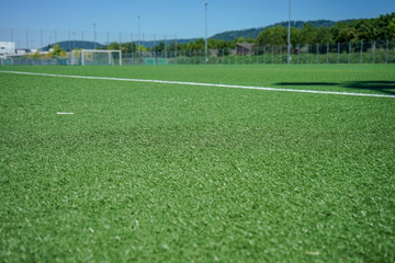 white lines and grean plastic grass on soccer or football field