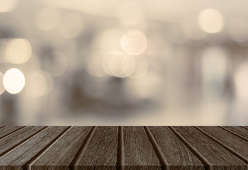 Empty perspective wood plank table top with abstract bokeh light background for montage of your product.