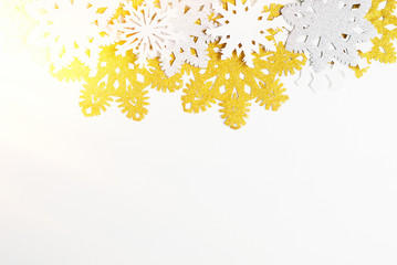 Golden, silver and white paper snowflakes on white background. New year, christmas concept. Text space
