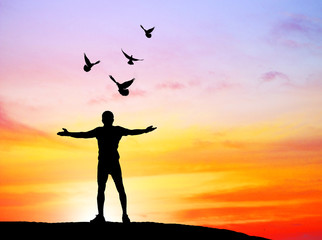 Fototapeta premium silhouette of bird flying out of man on sunrise