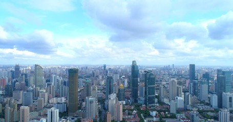 Aerial image showing cityscape of modern megacity with densely populated build environment.  Jing'an District shown in the foreground is one of the central districts of Shanghai. 