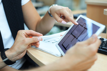 Real-estate agent showing house plans on electronic tablet.
