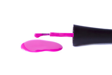 A brush from nail polish and a spilled varnish of purple on a white background