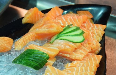 Sushi mit Lachs, Seetang, und Gurken auf einer Platte angerichtet