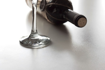 A bottle of red wine and wineglass on a table