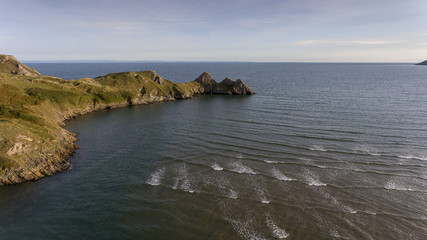 Fototapeta na wymiar Aerial view of the incoming tide at the dramatic Three Cliffs Bay on the Gower peninsula, Swansea, South Wales, UK 