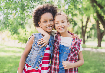 Two little girls hugging in the park