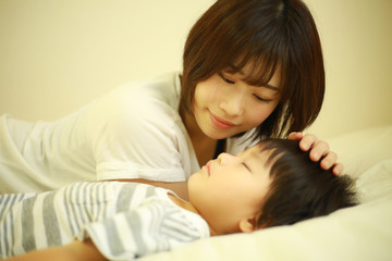 寝かせつける母親