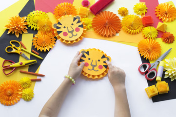 Children's DIY paper tiger. The child's hands