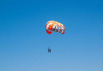 tourists on a parachute above the  beach in Malia. Crete, Greece