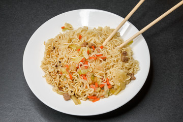 Instant noodles in white plate. Close-up.