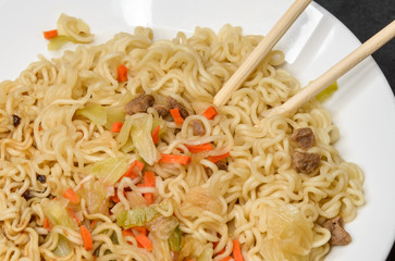 Instant noodles in white plate. Close-up.