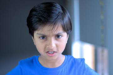 Angry child throwing tantrum. Upset kid grinding teeth.