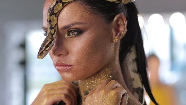 Woman with snake body art and serpent posing