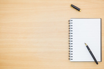Flat lay photography. Empty notebook and a pen on a wooden table. Write memo office idea concept.