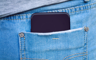 Black cell phone in the back pocket of jeans close-up