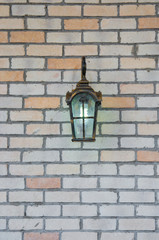 A medieval European-style retro style chandelier shines on a brick wall