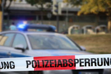 Polizeiabsperrung mit Polizeiauto im Hintergrund
