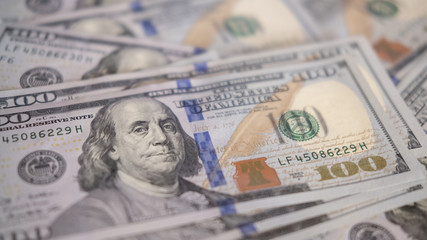 One hundred dollars pile as background.